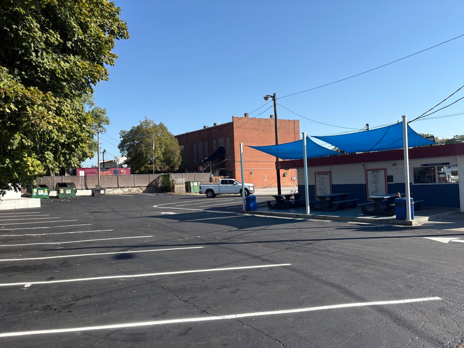 Finished sealcoated parking area and striping beside the blue canopies at Big Top Drive-In in Evansville