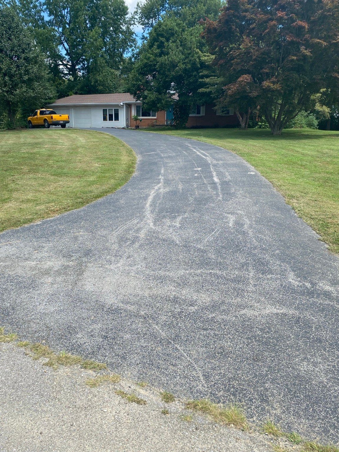 Residential asphalt driveway before sealcoating in Henderson County
