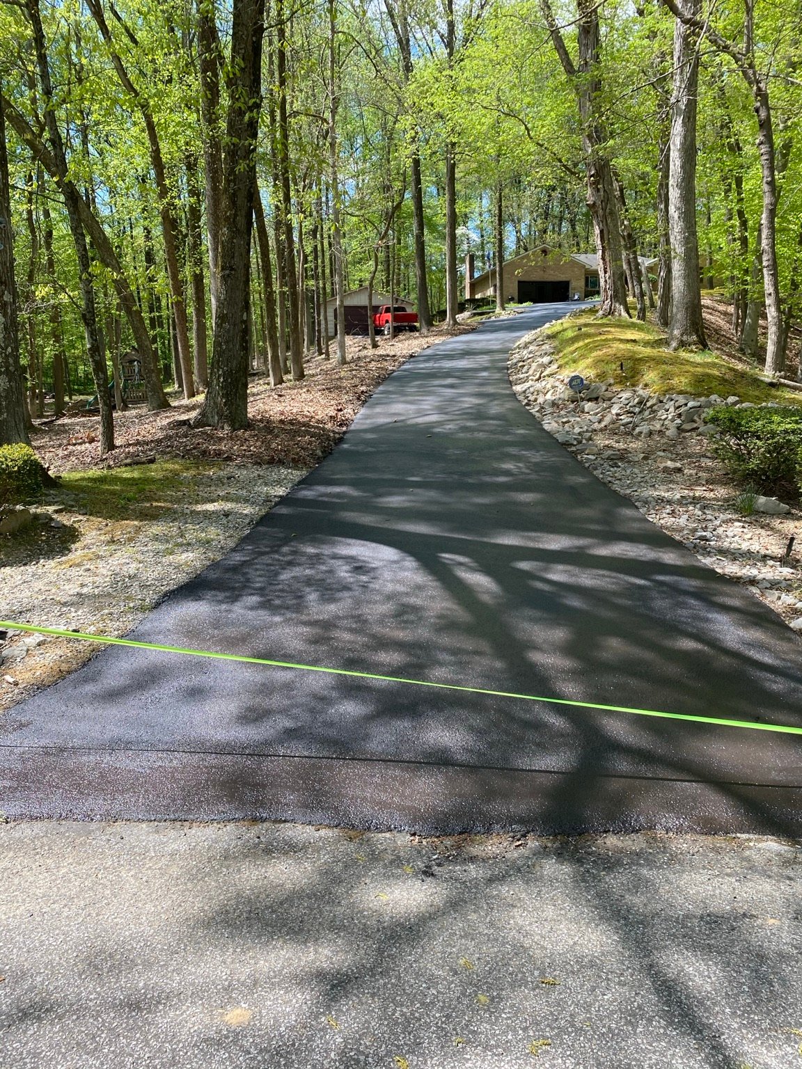 Freshly sealcoated wooded driveway in Henderson County
